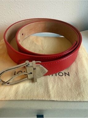 LV Women’s Epi belt in color, Coquelicot, a vibrant red-orange.
